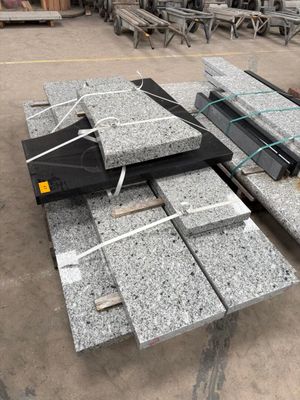 Plusieurs blocs de granit sont empilés les uns sur les autres dans un entrepôt