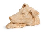 une statue représentant un chien couché sur une surface blanche