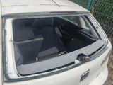 a small white car parked on the side of the road