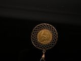 an image of a gold coin with a tassel hanging from it ' s side