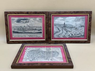 deux photos encadrées représentant une grande ville et une petite ville, posées sur une table