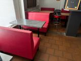 tables and chairs in a restaurant with a chalk board on the wall