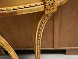 a gold table with a marble top on a tile floor