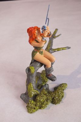 une figurine représentant une femme assise sur une branche d'arbre