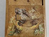 a small wooden box with a painting of a bird on it