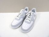 pair of white and grey sneakers on a white surface with a wall in the background