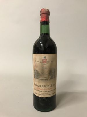 une vieille bouteille de vin posée sur une table blanche