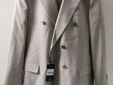 the jacket is hanging on a hanger on the wall