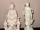 deux statues représentant une femme et un homme assis sur un banc