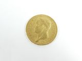 gros plan d'une pièce d'or sur une surface blanche