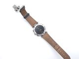the watch has a brown leather strap with a silver buckle