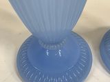 two blue vases sitting on a table with a white background