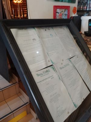 un menu dans un cadre noir posé sur le comptoir