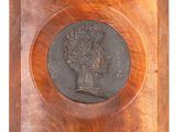 a close up of a wooden plaque with a bust of a man on it