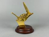 gold plated model of a star trek ship on a wooden base