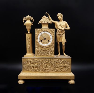 une image représentant une horloge en or sur laquelle figurent un homme et une femme