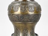 a large metal vase with a stand on a white background