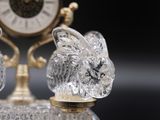 crystal figurines of a rabbit and a clock sitting on a table