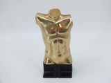 gold male torso sculpture on black base on white background