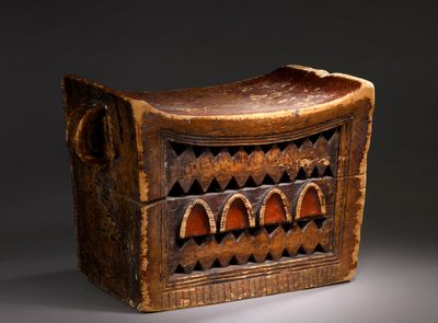 une vieille boîte en bois ornée d'un motif sculpté sur le devant