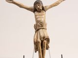 statue de Jésus sur la croix, posée sur un socle, sur fond blanc