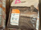 two bags of dog food sitting on a pallet