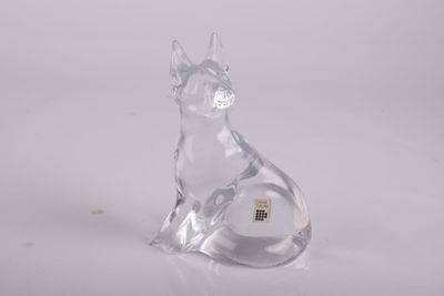 figurine de chat en verre transparent posée sur une surface blanche