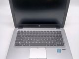 a silver laptop computer sitting on a white surface