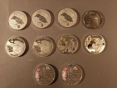 Plusieurs pièces de monnaie différentes sont disposées en rangée sur une table