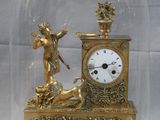 a gold clock under a glass dome on a table