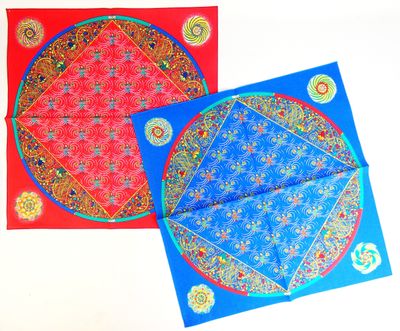 deux cartes rouges et bleues ornées de motifs, posées sur une surface blanche