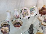 une vitrine en verre sur laquelle sont disposés de nombreux objets décoratifs
