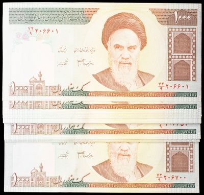 two bills with a picture of a man on them on a black background