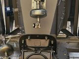 a picture of a toilet in a room with pipes and valves