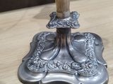 a silver candle that is on a wooden table