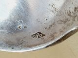a close up of a silver spoon with a hole in it
