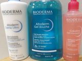 three bottles of body wash and a bottle of lotion sitting on a shelf
