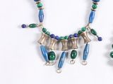 two necklaces with blue and green beads on a white surface