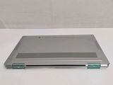 a silver laptop computer sitting on a white surface