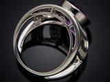 a close up of a ring with a purple stone in it