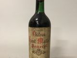 an old bottle of wine sitting on top of a white table