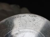a close up of a metal bowl with writing on it