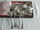 a lot of spoons and forks in a box on a table