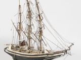 a model of a ship on a stand on a white surface