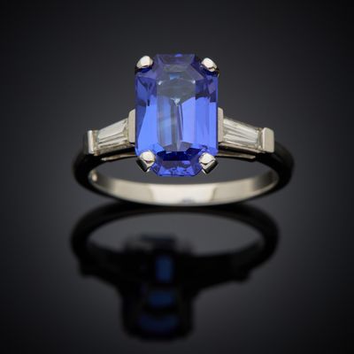 a blue sapphire and diamond ring on a black surface