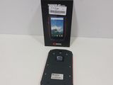 a black cell phone sitting in front of a box