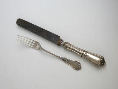 deux fourchettes et un couteau sur une table blanche