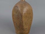 a brown vase sitting on a table with a gray background
