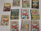 Plusieurs livres pour enfants sont alignés sur un sol carrelé