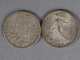 a close up of two silver coins on a gray surface